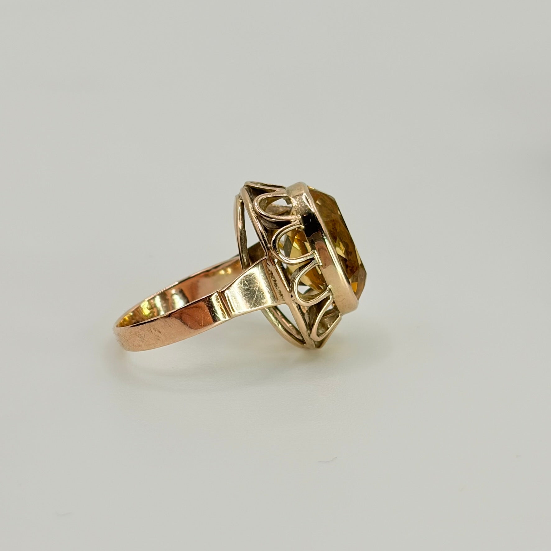 Goldring mit ovalem Citrin in geometrischer Fassung, Seitenansicht am Ringfinger.