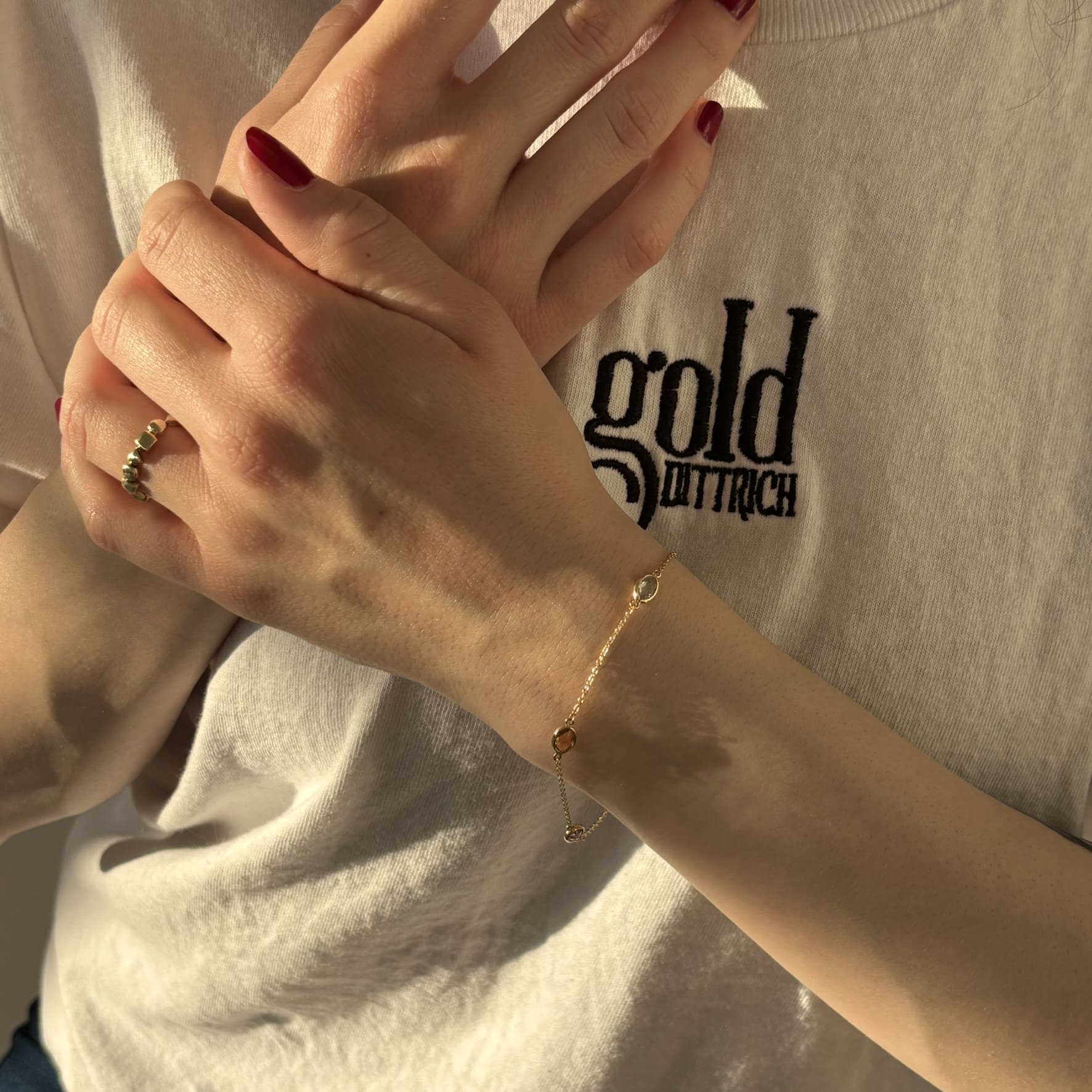 Filigranes Ankerarmband aus 585 Gelbgold mit Amethyst, Citrin und behandeltem Blautopas, getragen am Handgelenk – eleganter Damenschmuck von Gold Dittrich.