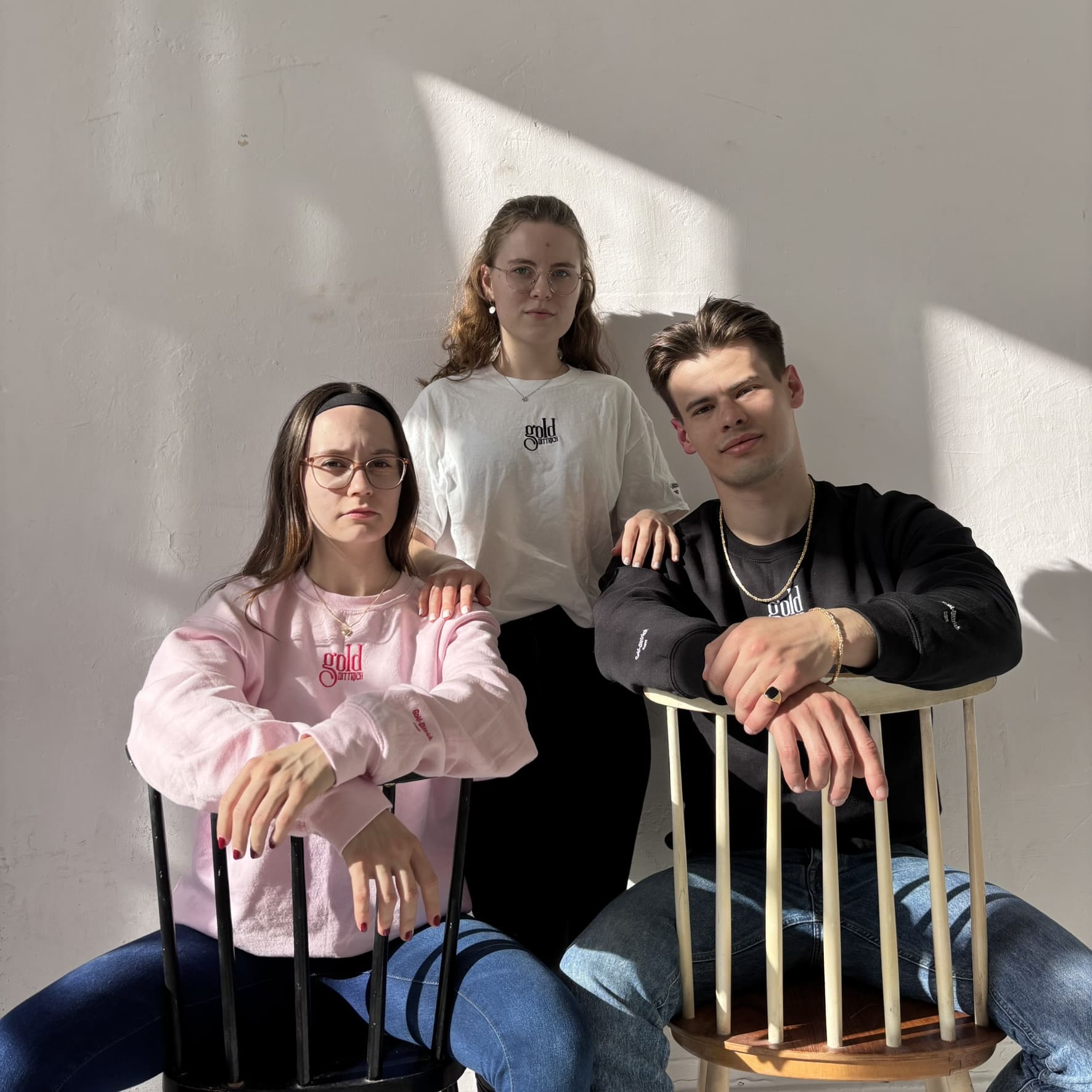 Drei junge Models tragen Gold Dittrich Schmuck und Sweatshirts im Sonnenlicht – moderne Schmuckkollektion für Frauen und Männer mit Stil und Haltung