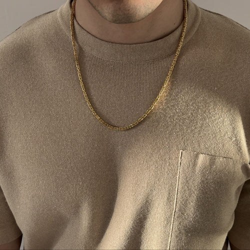 Mann mit beigefarbenem Shirt trägt eine vergoldete Königskette aus 925 Sterling Silber mit diamantierter Oberfläche – massiver Herrenschmuck mit ca. 60 cm Länge, stilvoll präsentiert von Gold Dittrich.