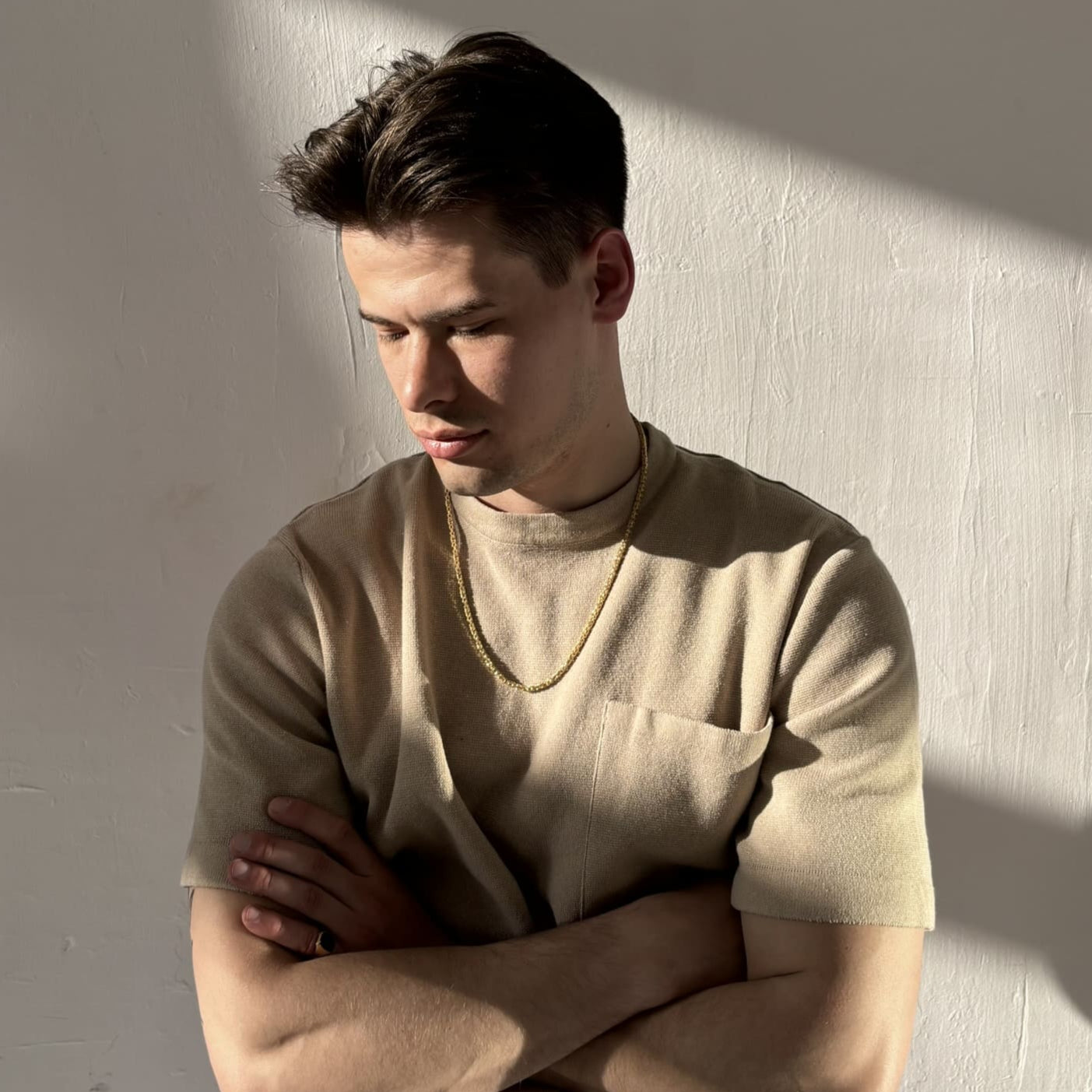 Mann mit beigefarbenem Shirt steht verschränkt im Sonnenlicht und trägt eine vergoldete, diamantierte Königskette aus 925 Sterling Silber – massives Herrenschmuckstück mit ca. 60 cm Länge, präsentiert von Gold Dittrich.