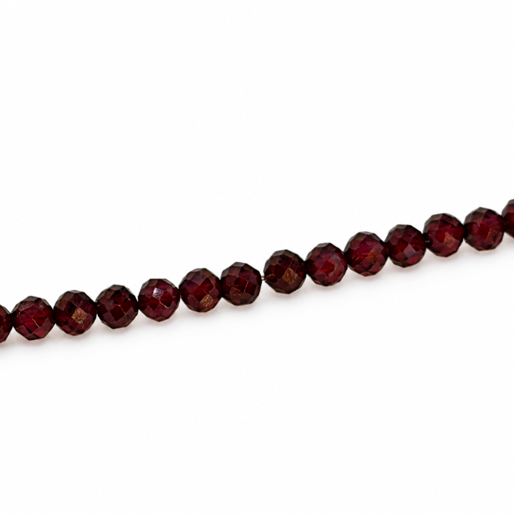 Granat-Armband: Reihe dunkler Granatkugeln mit silbernen Verbindungsgliedern, teilweise sichtbar