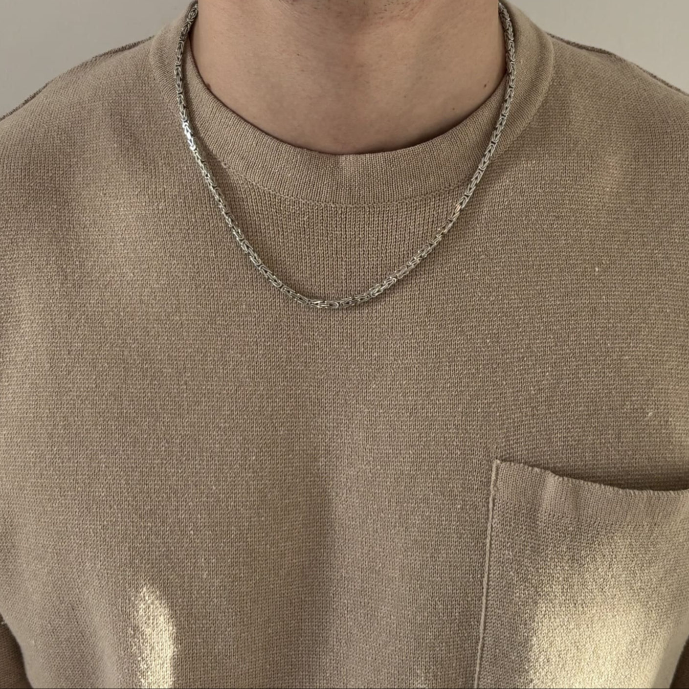 Mann mit beigefarbenem Shirt trägt eine Königskette aus rhodiniertem 925 Sterling Silber mit ca. 55 cm Länge – massiver Herrenschmuck mit stabilem Karabinerverschluss, hochwertig verarbeitet von Gold Dittrich.