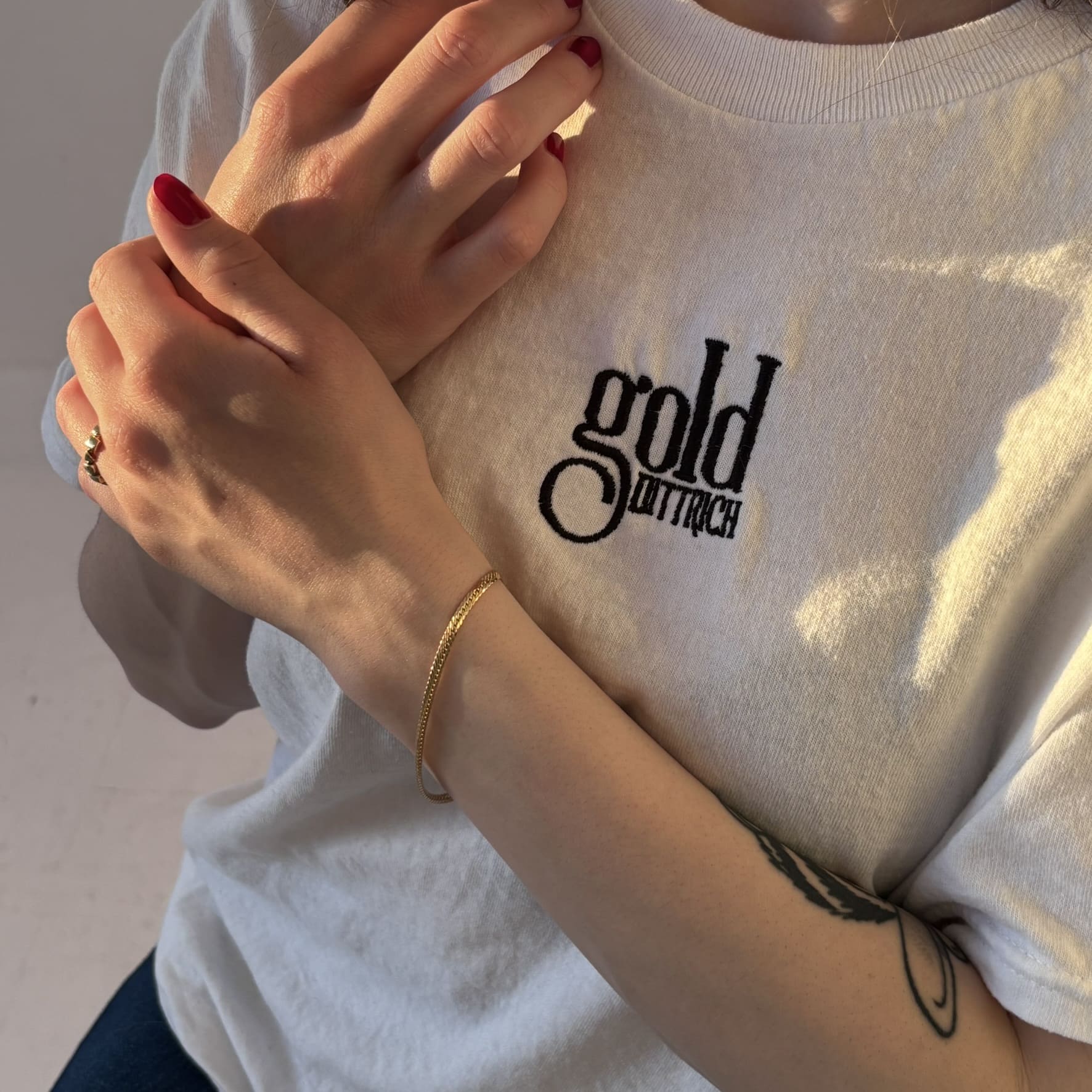 Feines Schlangenarmband aus 750 Gelbgold mit 3 mm Breite, getragen von einer Frau im Gold Dittrich Shirt – elegantes Vintage-Armband mit dezentem Glanz.
